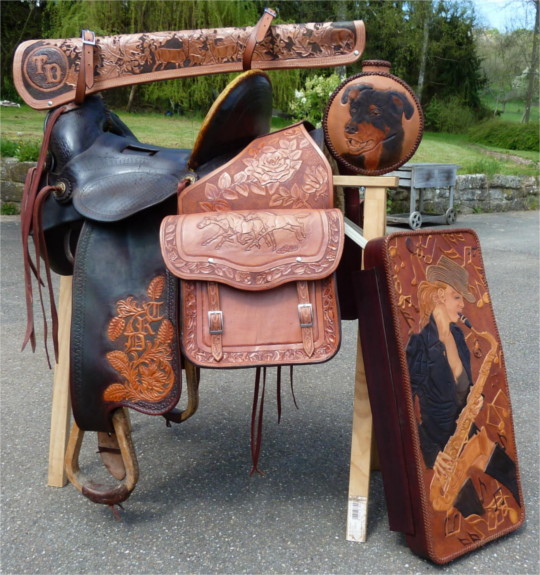 Collection of various items. Refurbished saddle, gun scabbard, canteen, saddlebags and lid of a saxophone case.